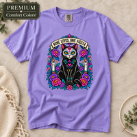 Load image into Gallery viewer, Violet Comfort Colors tee with Nine Lives, One Fiesta Día de Muertos black cat design, flowers and candles

