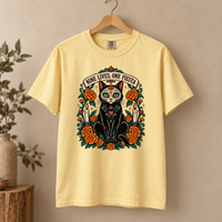 Load image into Gallery viewer, Butter yellow Nine Lives, One Fiesta Day of the Dead black cat tee with marigolds on a wooden hanger
