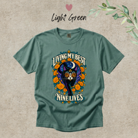 Load image into Gallery viewer, Living My Best Nine Lives Day of the Dead black cat t-shirt with marigolds in Light Green, Comfort Colors
