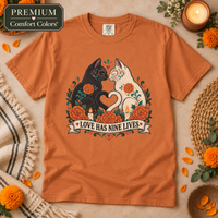 Load image into Gallery viewer, Love Has Nine Lives Day of the Dead black cat t-shirt in Yam, Comfort Colors, flat lay with marigolds and candles
