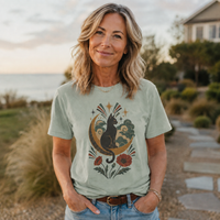 Load image into Gallery viewer, Celestial cat t-shirt with a black cat, crescent moon and rust-coloured poppies, printed on soft Comfort Colors cotton
